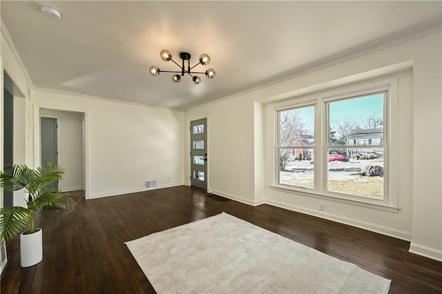 unfurnished room with a notable chandelier, crown molding, and dark wood-type flooring