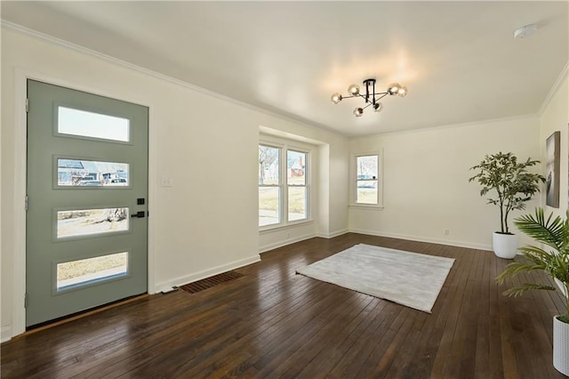 foyer entrance with an inviting chandelier, crown molding, and dark hardwood / wood-style floors