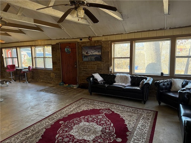 living room featuring wooden walls, ceiling fan, and vaulted ceiling