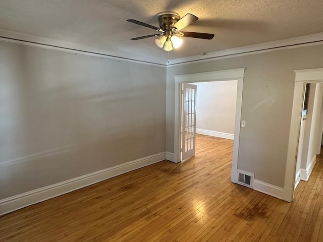 unfurnished room with ceiling fan, ornamental molding, light hardwood / wood-style flooring, and a textured ceiling