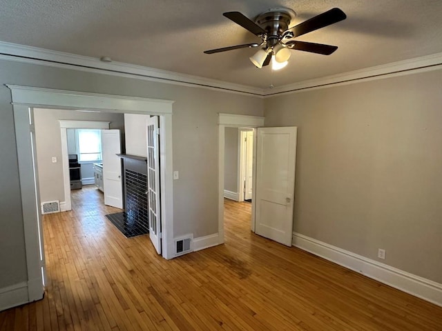 interior space with crown molding, ceiling fan, and light hardwood / wood-style flooring