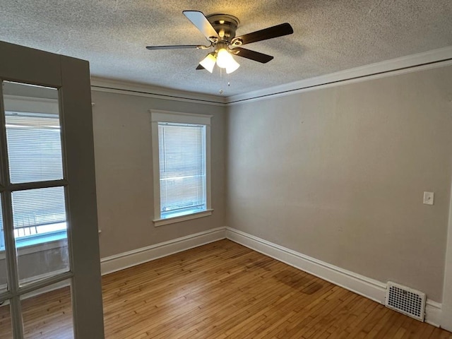 spare room featuring ceiling fan, crown molding, a textured ceiling, and light hardwood / wood-style floors