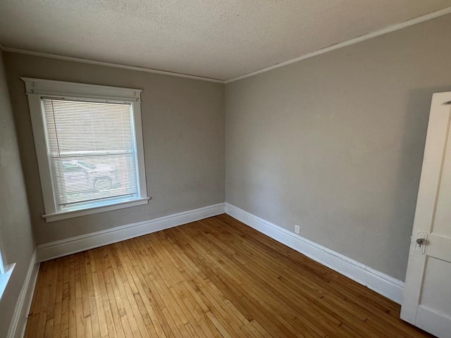 unfurnished room with crown molding, light hardwood / wood-style floors, and a textured ceiling