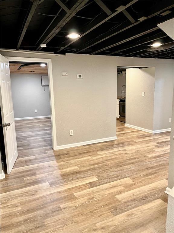 basement with light hardwood / wood-style flooring