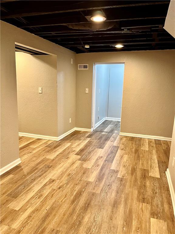 basement with light hardwood / wood-style floors