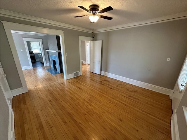 unfurnished room with ceiling fan, ornamental molding, light hardwood / wood-style flooring, and a textured ceiling