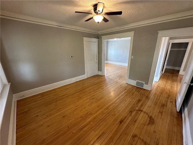 spare room with ornamental molding, wood-type flooring, ceiling fan, and a textured ceiling