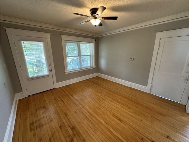 interior space featuring ceiling fan, ornamental molding, light hardwood / wood-style flooring, and a textured ceiling