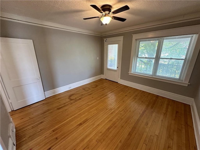 unfurnished bedroom featuring ceiling fan, ornamental molding, light hardwood / wood-style flooring, and a textured ceiling