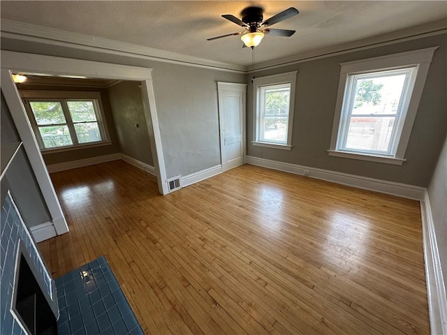 unfurnished bedroom with hardwood / wood-style flooring, ornamental molding, ceiling fan, and a textured ceiling