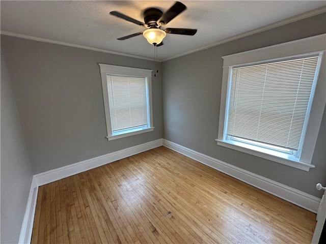 empty room with ceiling fan, ornamental molding, light hardwood / wood-style flooring, and a textured ceiling