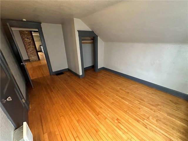 bonus room with hardwood / wood-style flooring and lofted ceiling