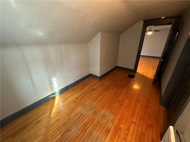 bonus room with lofted ceiling and light wood-type flooring