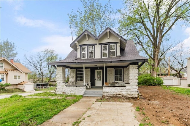 view of front of house with an outbuilding, a porch, and a garage