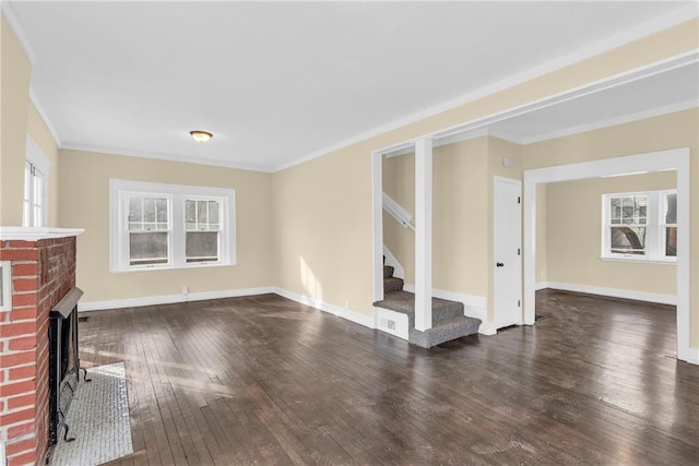 unfurnished living room featuring a fireplace, ornamental molding, dark hardwood / wood-style floors, and plenty of natural light