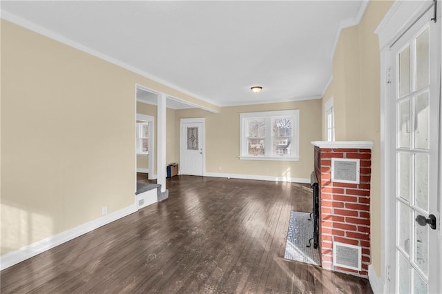 unfurnished living room featuring a fireplace, crown molding, and dark wood-type flooring