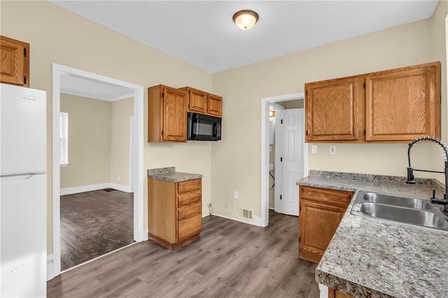 kitchen with white fridge, sink, and hardwood / wood-style floors