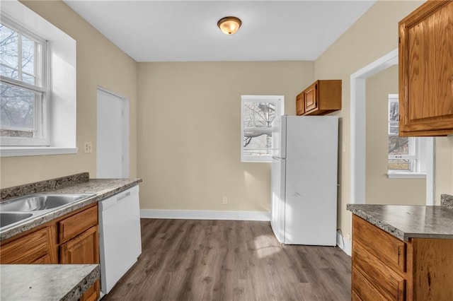 kitchen with white appliances, plenty of natural light, and wood-type flooring