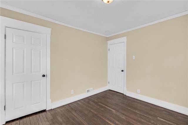 empty room with ornamental molding and dark hardwood / wood-style floors