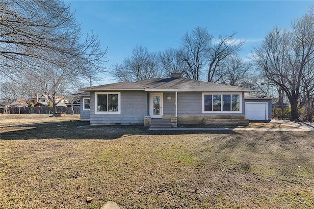 view of front of house featuring entry steps, a chimney, a front yard, and a garage