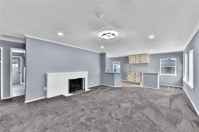 unfurnished living room with a fireplace with flush hearth, dark colored carpet, ornamental molding, and baseboards