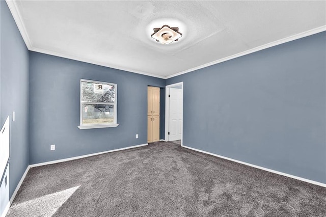 empty room with crown molding, dark carpet, and baseboards