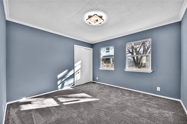 unfurnished room featuring carpet floors, a textured ceiling, baseboards, and crown molding