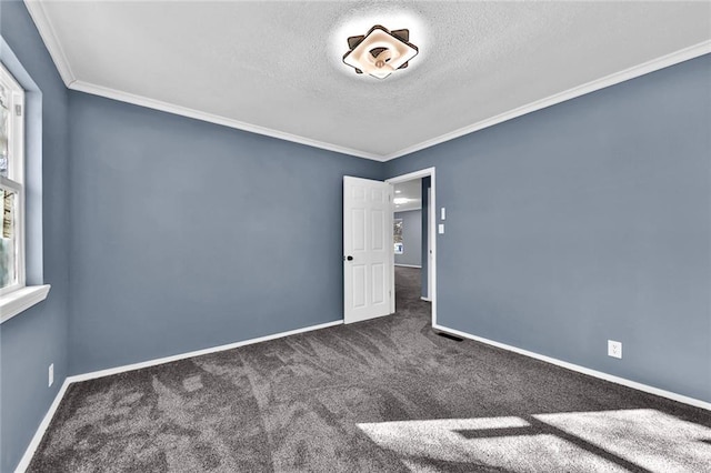 unfurnished bedroom featuring a textured ceiling, ornamental molding, carpet flooring, and baseboards