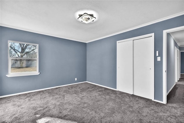 unfurnished bedroom featuring baseboards, carpet, ornamental molding, and a closet