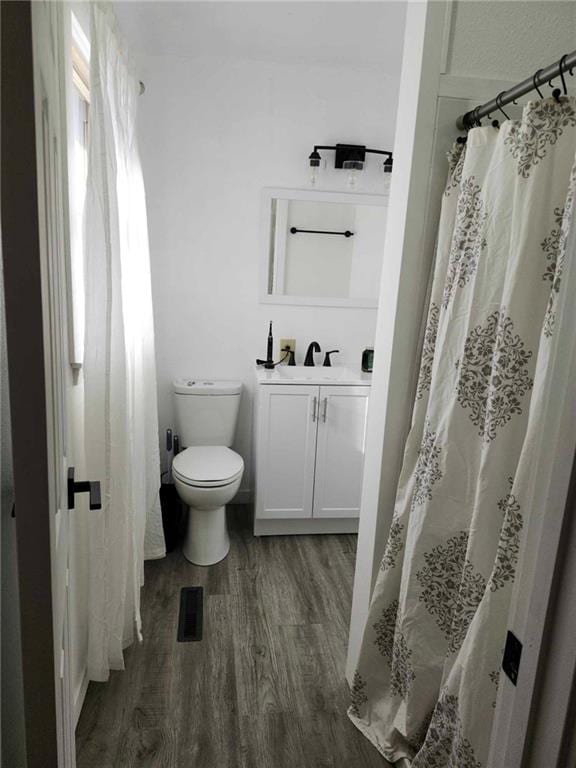 bathroom with wood-type flooring, toilet, and sink