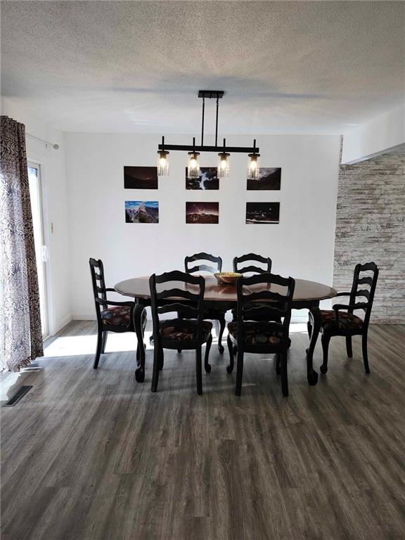 dining area featuring dark hardwood / wood-style flooring and a textured ceiling