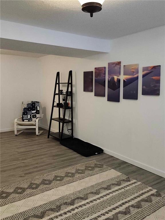 interior space with a textured ceiling and dark hardwood / wood-style flooring