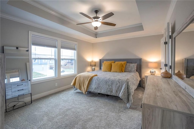 bedroom with crown molding, a tray ceiling, carpet floors, and ceiling fan