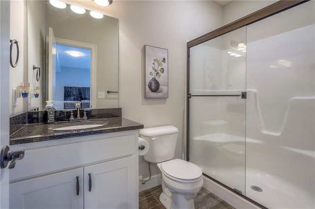 bathroom featuring walk in shower, vanity, and toilet