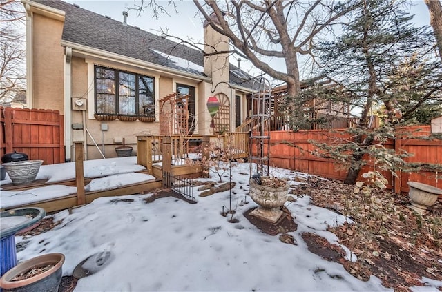 snowy yard with a deck