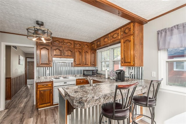 kitchen featuring pendant lighting, sink, a textured ceiling, dark hardwood / wood-style flooring, and kitchen peninsula