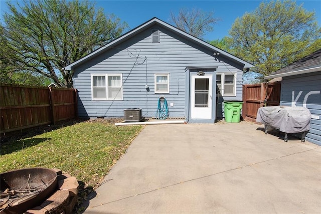 back of property with a patio, central air condition unit, and an outdoor fire pit