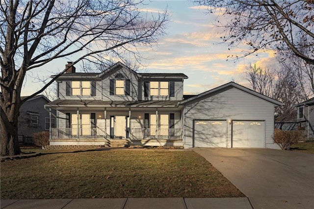 view of front of property featuring a porch, a garage, and a yard