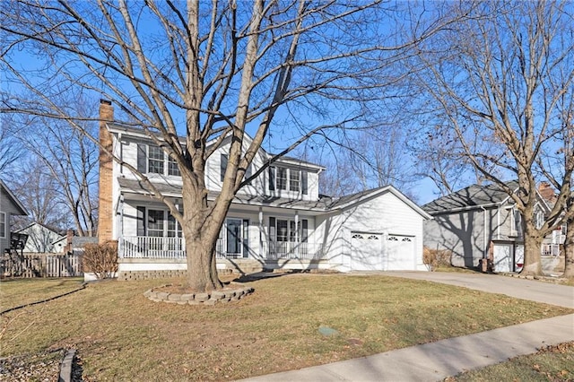 view of front of property featuring a garage, a front lawn, and covered porch