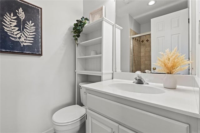 bathroom with vanity, tiled shower, and toilet