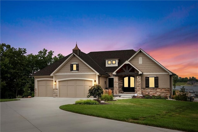 craftsman house featuring a garage and a yard