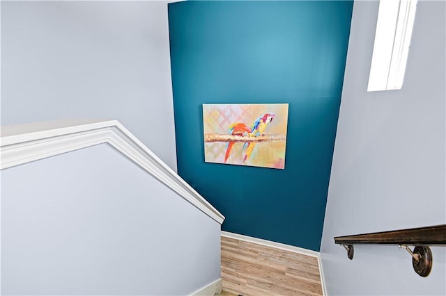 stairway with wood finished floors and baseboards