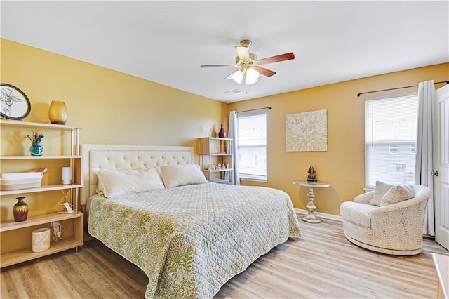 bedroom featuring visible vents, ceiling fan, baseboards, and wood finished floors