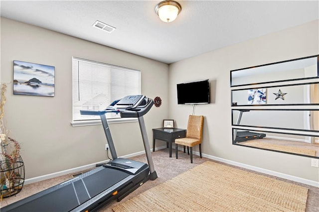 workout area with baseboards, visible vents, and carpet flooring