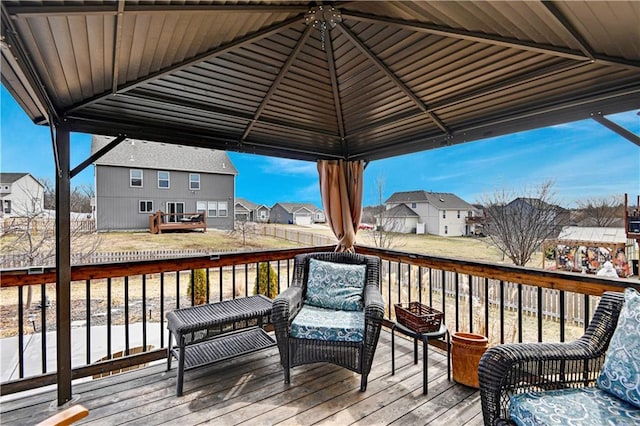 wooden deck with a residential view, a lawn, and a gazebo