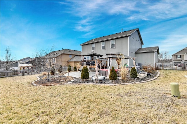 back of house with a gazebo, a yard, and a fenced backyard