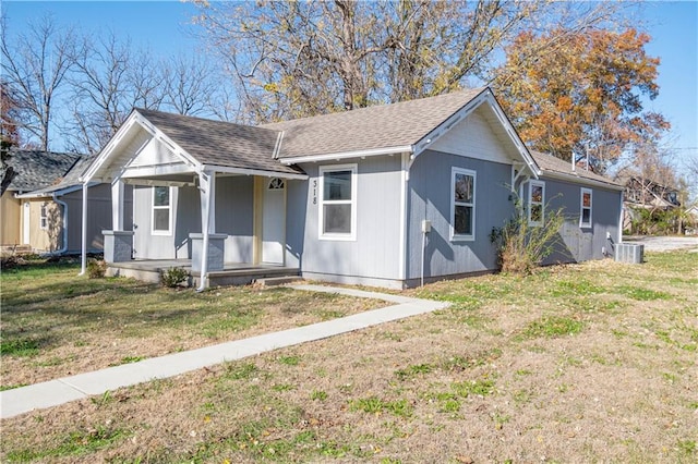 view of front of home featuring covered porch, a front yard, and central air condition unit