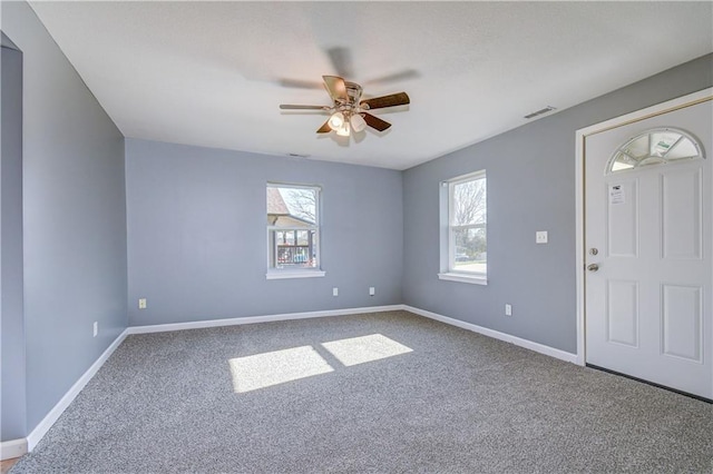 entrance foyer with ceiling fan and carpet flooring