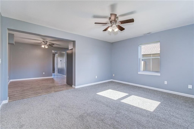 carpeted spare room featuring ceiling fan