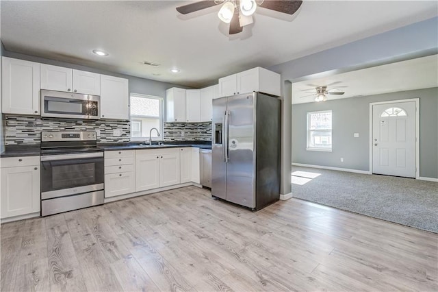 kitchen featuring backsplash, appliances with stainless steel finishes, sink, and white cabinets